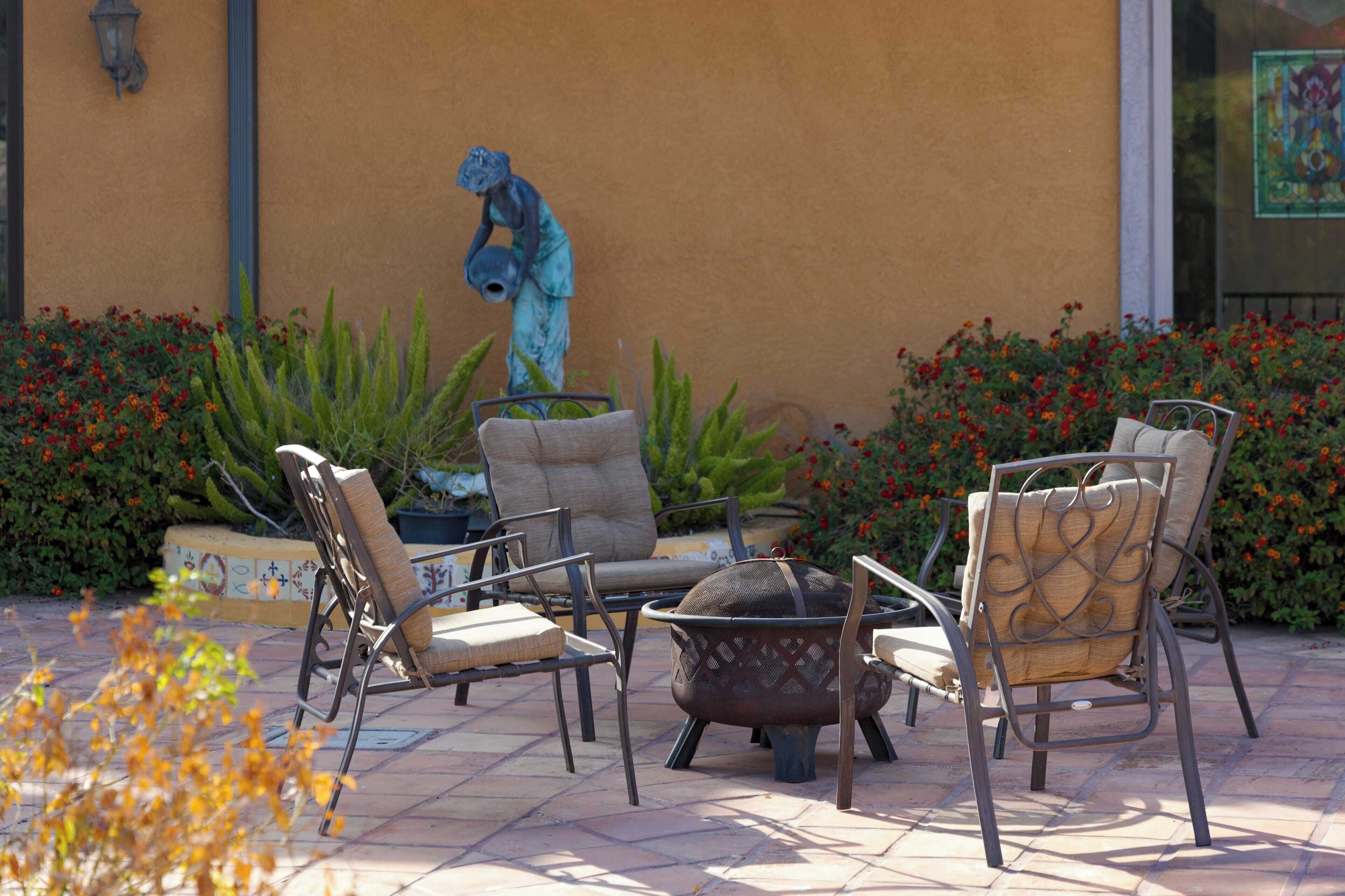 An outdoor seating area with metal chairs and a fire pit.