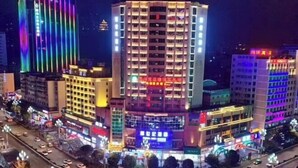 A multi-story hotel with illuminated signage and a busy street in the foreground. - Kaili New Century Hotel (Grand Cross of International Trade Shopping Center) (Kaili)