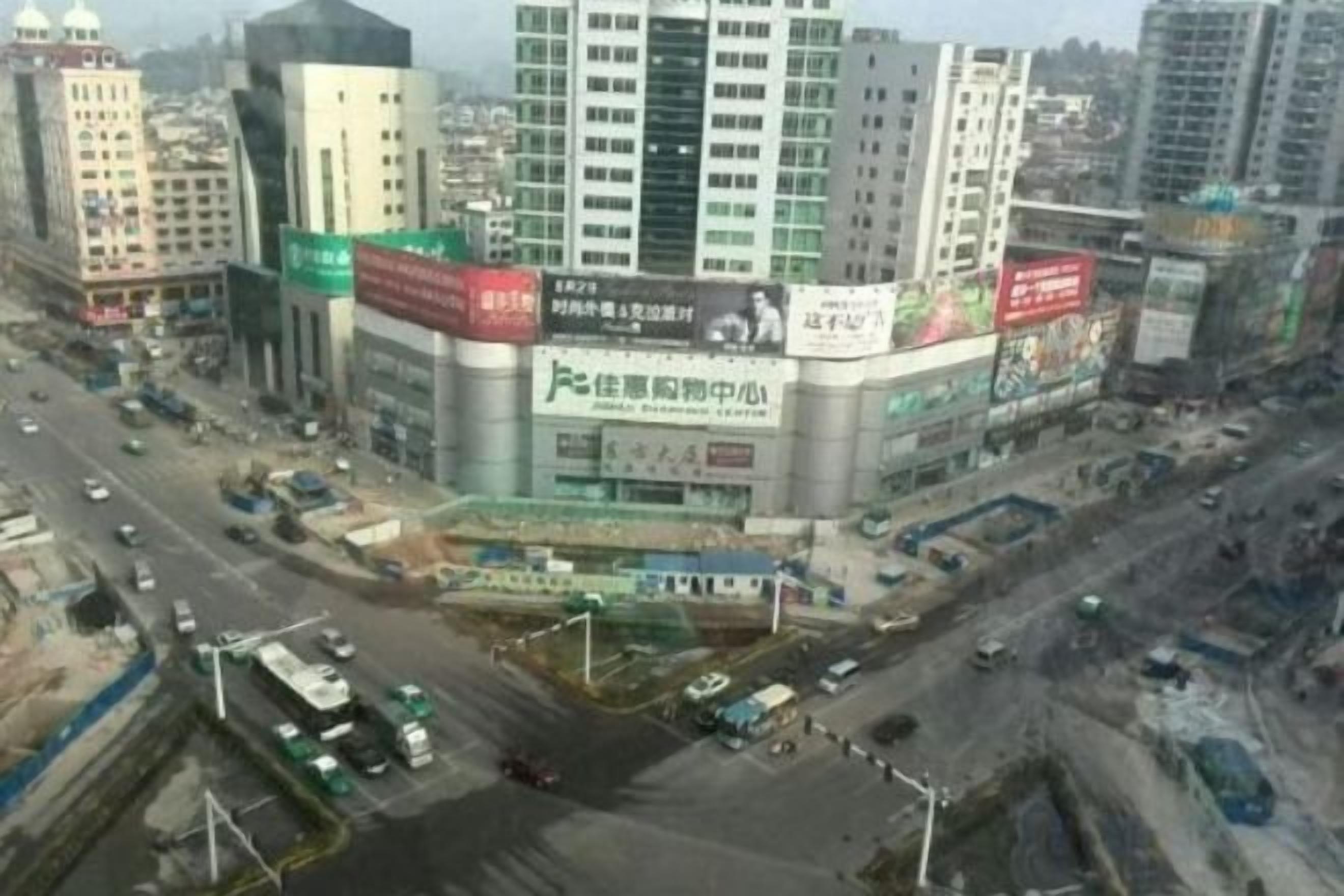 A multi-story building with a prominent sign and a busy street in front.