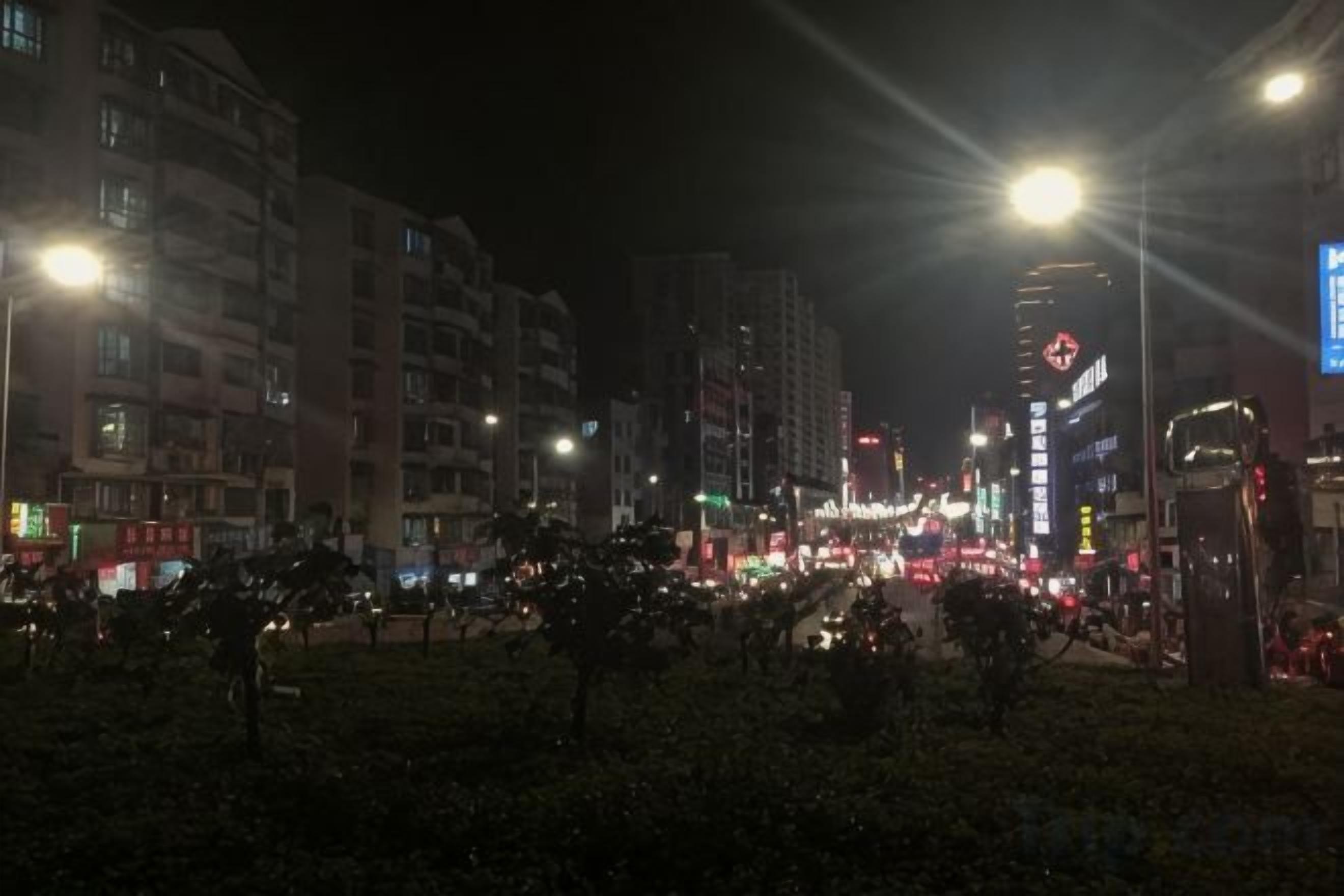 A nighttime cityscape with illuminated buildings and streetlights.