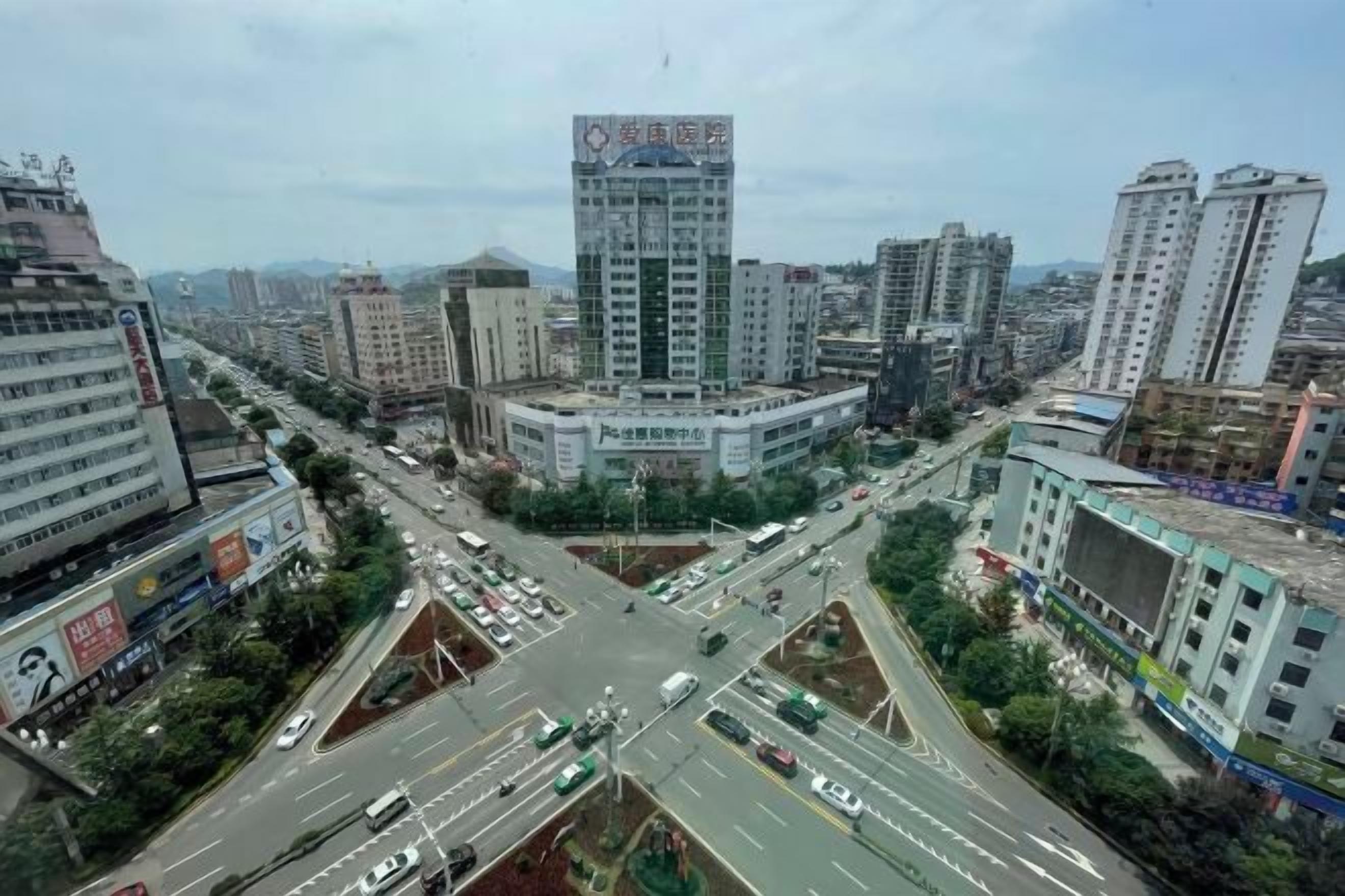 Paisatge urbà amb diversos edificis alts, una rotonda central i carreteres que s'incrossen.