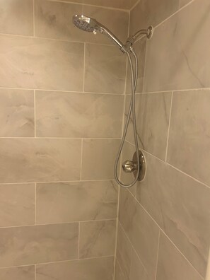 Enjoy a refreshing shower with a handheld showerhead and wall-mounted fixture.