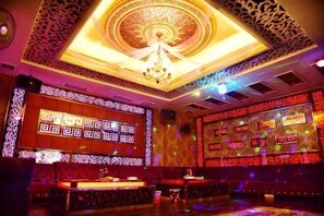 A hotel lobby with a large screen displaying patterns, a chandelier, and a bar area. - Saiqi Hotel (Fu'an)