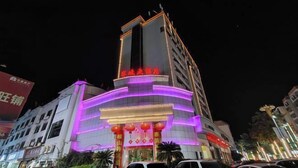 A hotel with a modern design, featuring a prominent entrance with illuminated signage and traditional red lanterns. - Saiqi Hotel (Fu'an)