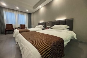 A hotel room with two beds, a desk, and a chair. - Saiqi Hotel (Fu'an)