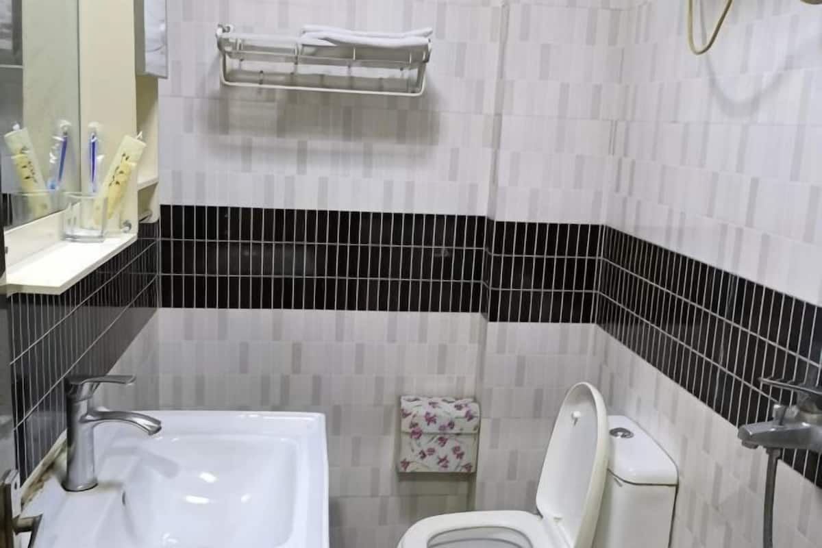 A bathroom with a white sink, toilet, and a towel rack.