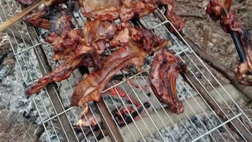 A grill with various meats being cooked.