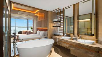 Une salle de bain moderne avec une grande baignoire, deux lavabos et un grand miroir.