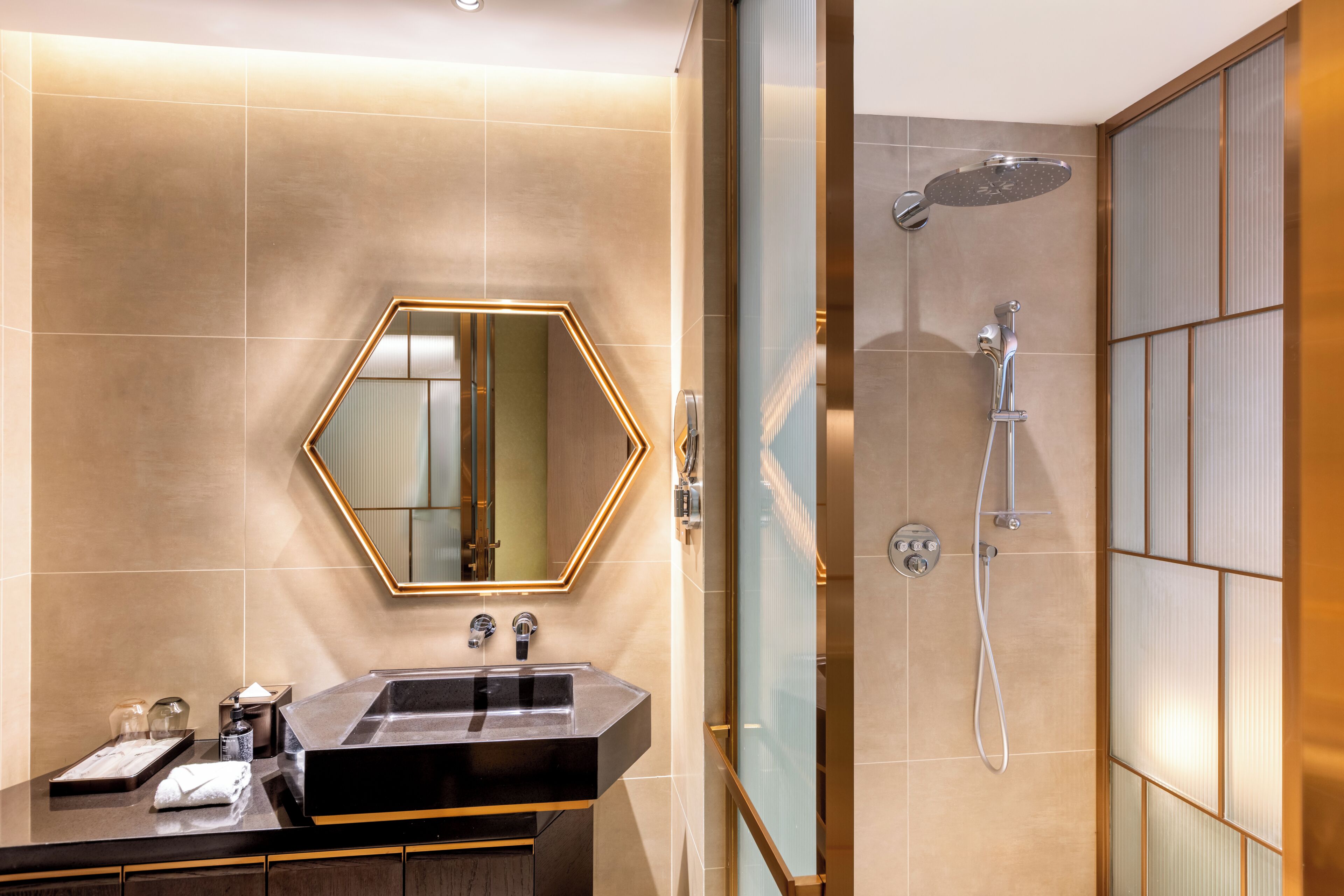 A modern bathroom with a large mirror, a sink, and a shower.