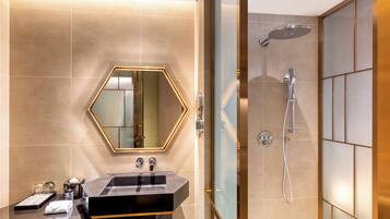 A modern bathroom with a large mirror, a sink, and a shower.