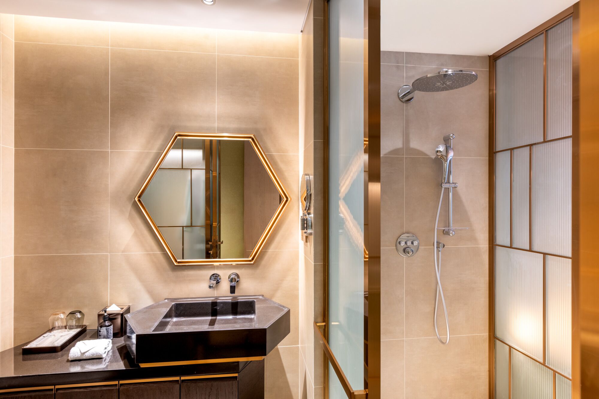 A modern bathroom with a large mirror, a sink, and a shower.