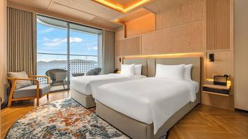 Une chambre d’hôtel avec deux lits, une grande fenêtre donnant sur un beau paysage, un plancher en bois et un design moderne.