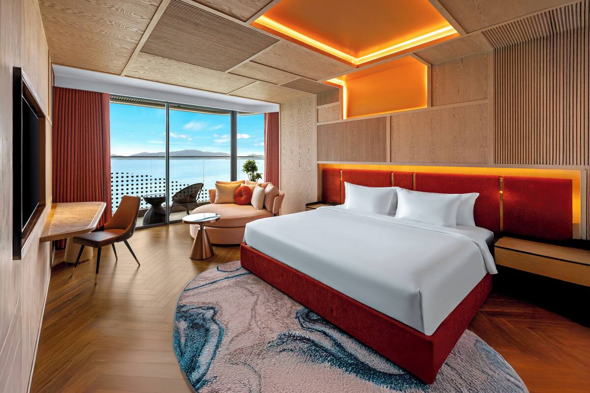 Ein modernes Hotelzimmer mit einem großen Bett, einem Schreibtisch und einer Sitzecke.