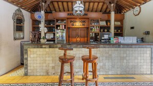 Eine Bar mit zwei Barhocker, einem Holzboden und einem Deckenventilator.