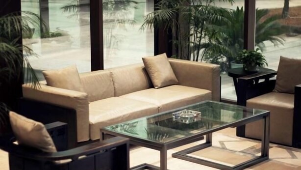 A modern living room with a beige sofa, a glass coffee table, and a black armchair. - Geheyan Hotel (Yichang)