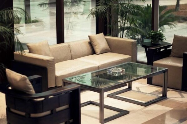 A modern living room with a beige sofa, a glass coffee table, and a black armchair. - Geheyan Hotel (Yichang)
