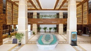 A spacious lobby with a central water feature, wooden paneling, and a modern design. - Geheyan Hotel (Changyang)