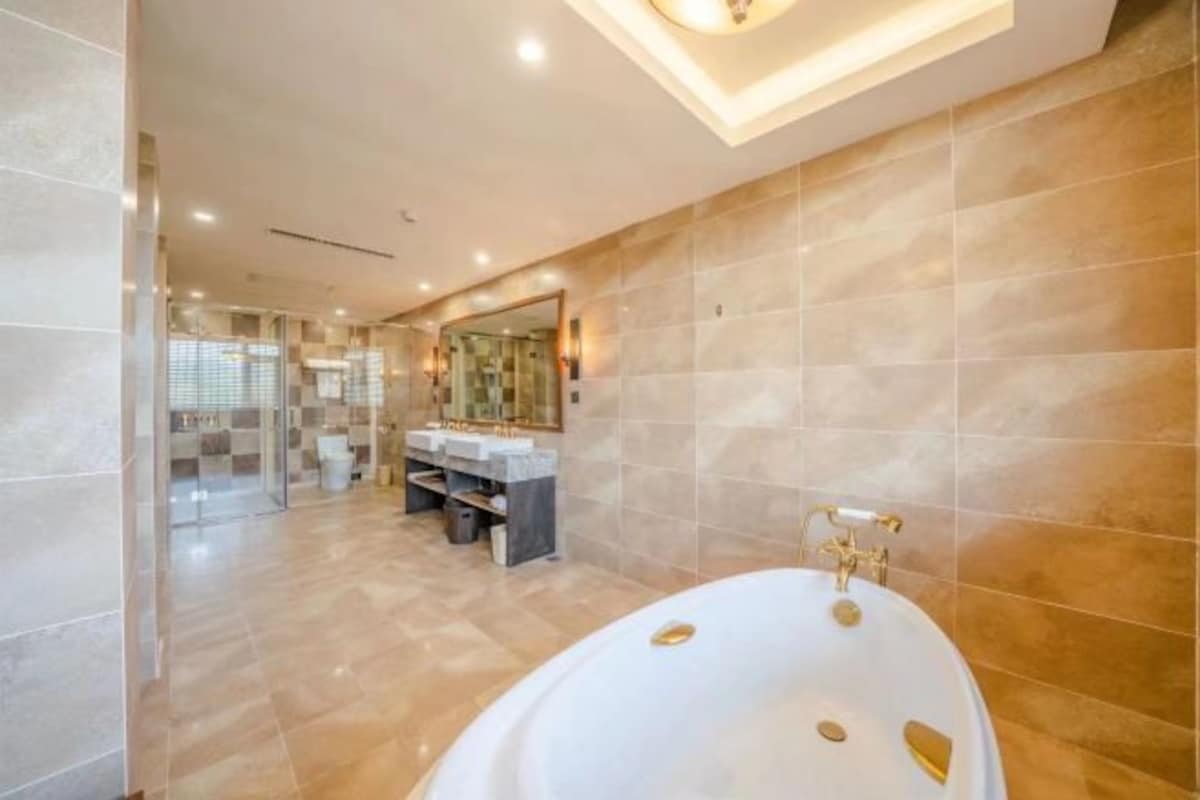 A modern bathroom with a large bathtub, a vanity with a mirror, and a shower area.
