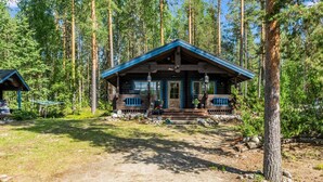 Eine Hütte mit blauem Dach, umgeben von hohen Kiefern.