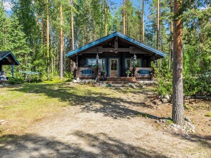 A cabin with a porch, surrounded by tall trees. - Kärppälä by Interhome (Savonlinna)