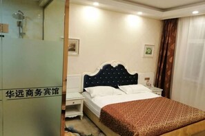 Une chambre d’hôtel comprenant un lit, des tables de chevet, une commode, un miroir et un espace douche.
