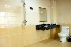 Un baño con ducha, lavamanos e inodoro.