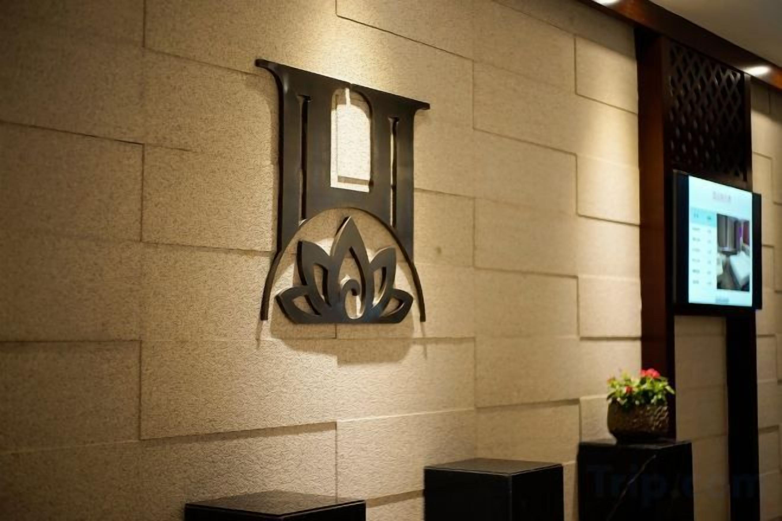 A wall with a decorative metal piece and a framed picture.
