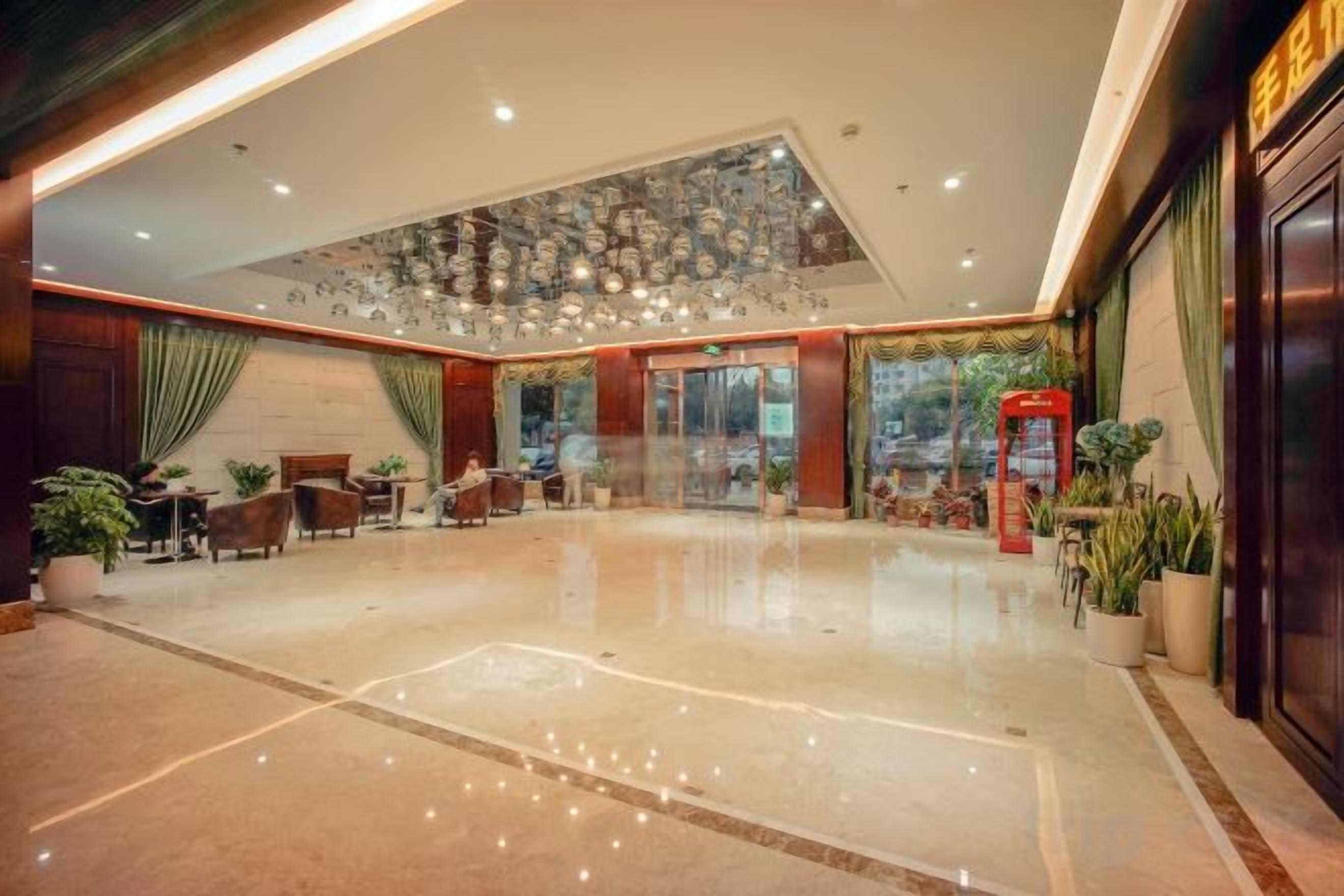 A spacious lobby with a high ceiling, a reception desk, and several seating areas.