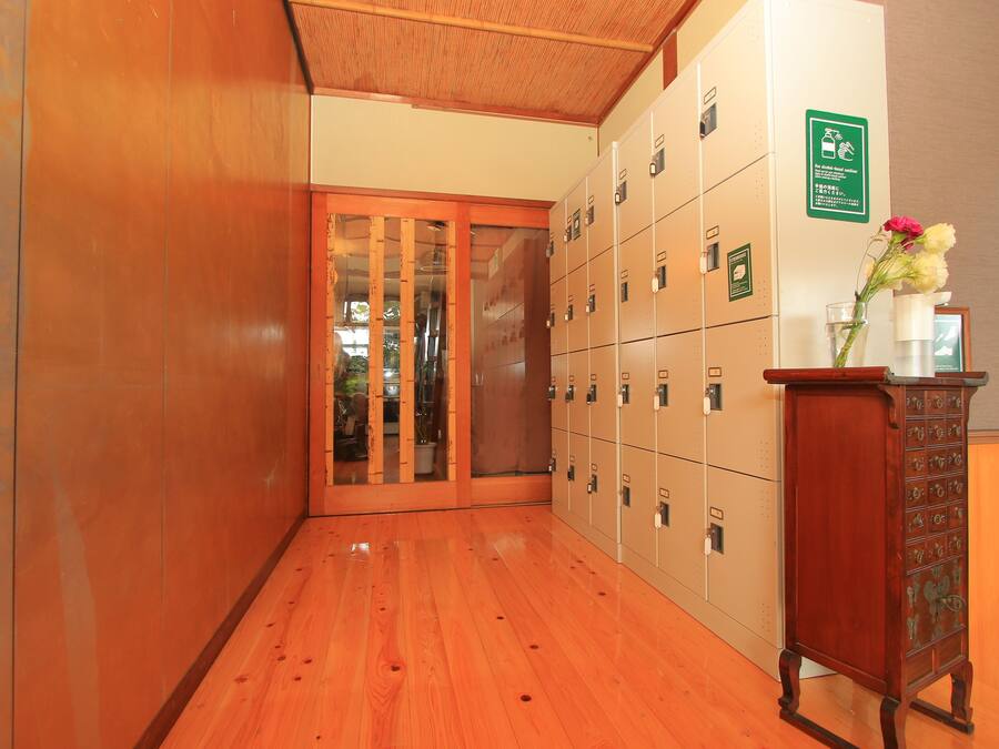 Ein Flur mit Holzböden, einem Schrank mit Schubladen und einer Glastür zu einem Raum.