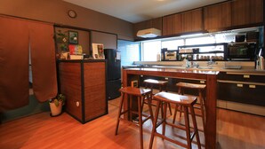 Una cocina moderna con armarios de madera, una isla central con taburetes, horno empotrado y un amplio ventanal que proporciona luz natural.