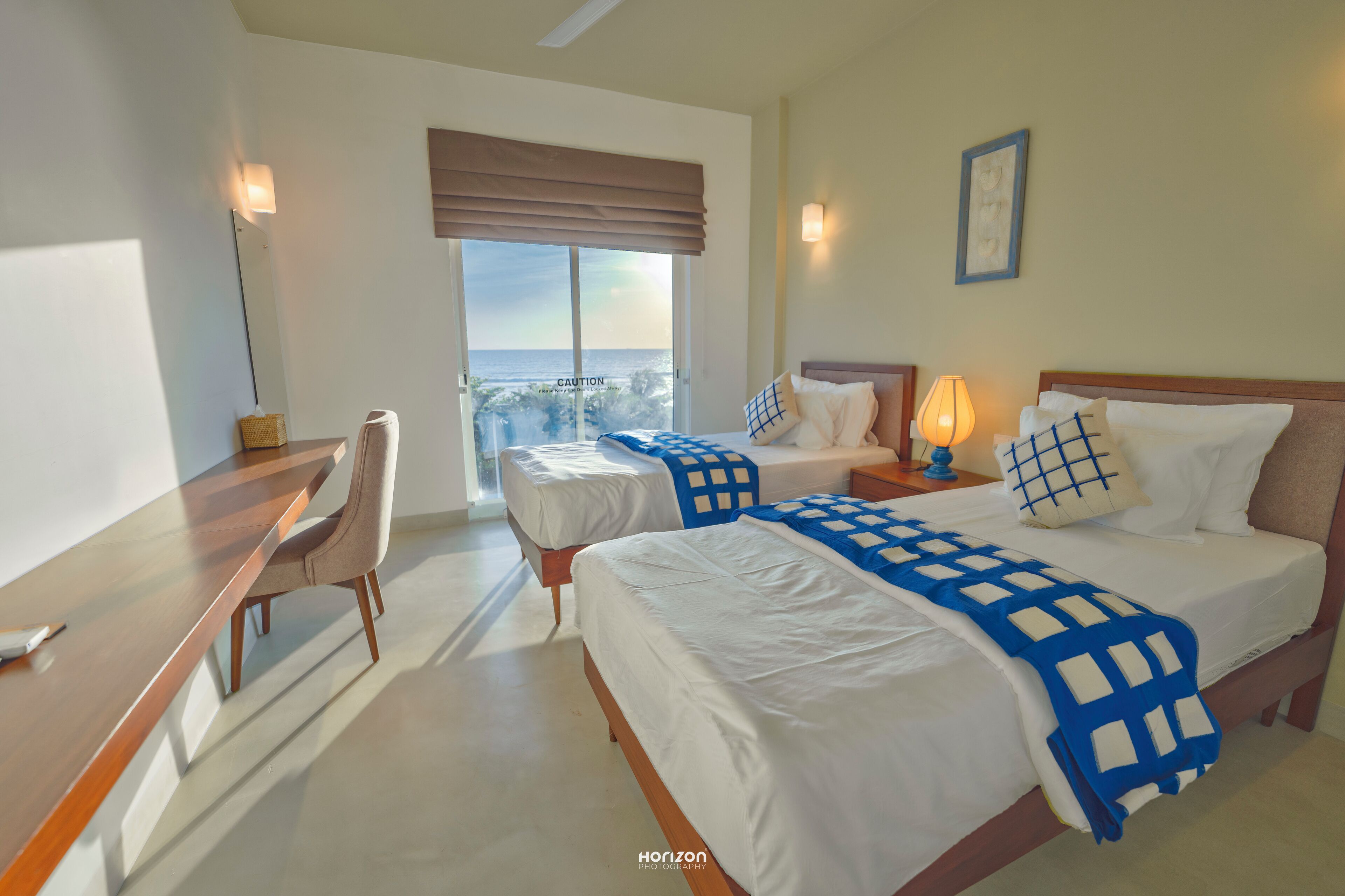 Habitación de hotel con dos camas, un escritorio y una silla.