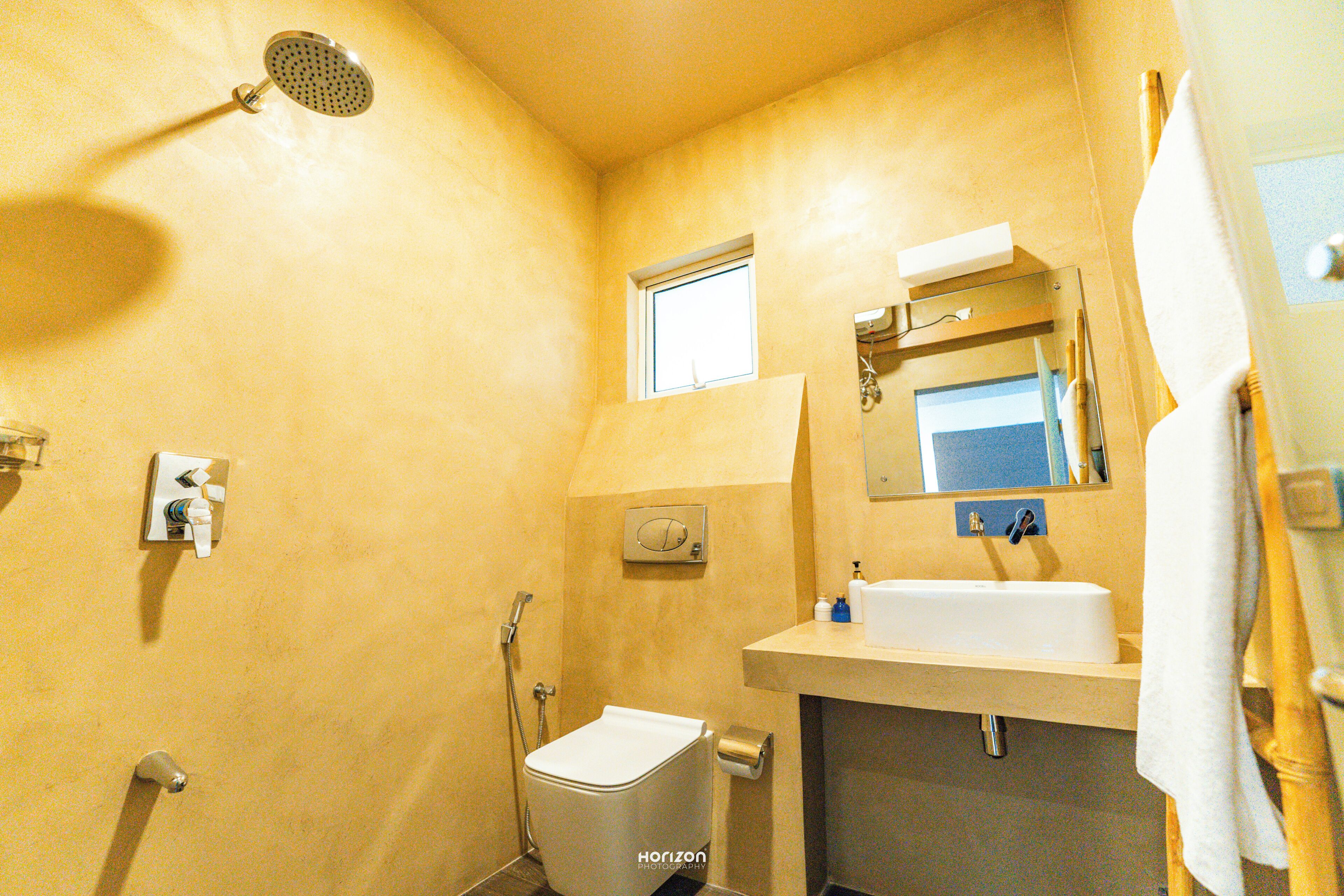 A compact bathroom with a shower, toilet, and sink.
