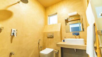 A compact bathroom with a shower, toilet, and sink.