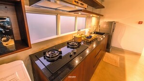 Una cocina moderna con encimera negra, electrodomésticos de acero inoxidable y armarios de madera.