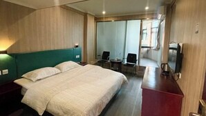 A hotel room with a large bed, a desk, a chair, and a small table. - Jinkairui Hotel Lijiang (Lujiang)