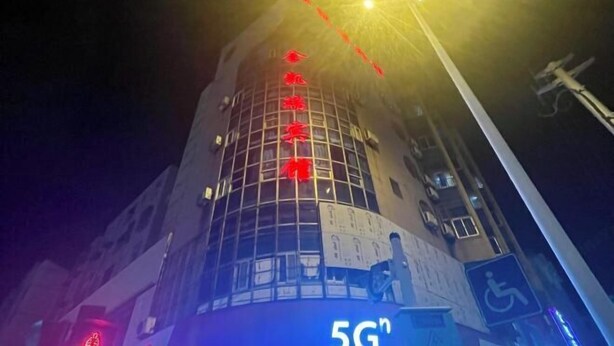 A building with a prominent 5G sign and red Chinese characters on its facade. - Jinkairui Hotel Lijiang (Lujiang)