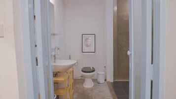 A bathroom with a sink, toilet, and a framed picture on the wall.