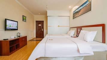 A hotel room with a bed, a TV, a wooden cabinet, and a painting on the wall.