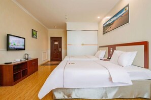 Une chambre d’hôtel avec un lit, une télévision, une armoire en bois et un tableau au mur.