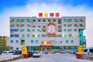 A hotel with a large sign, multiple floors, and a parking lot. - Super 8 Hotel (Korla Tianshan West Road) (Korla)