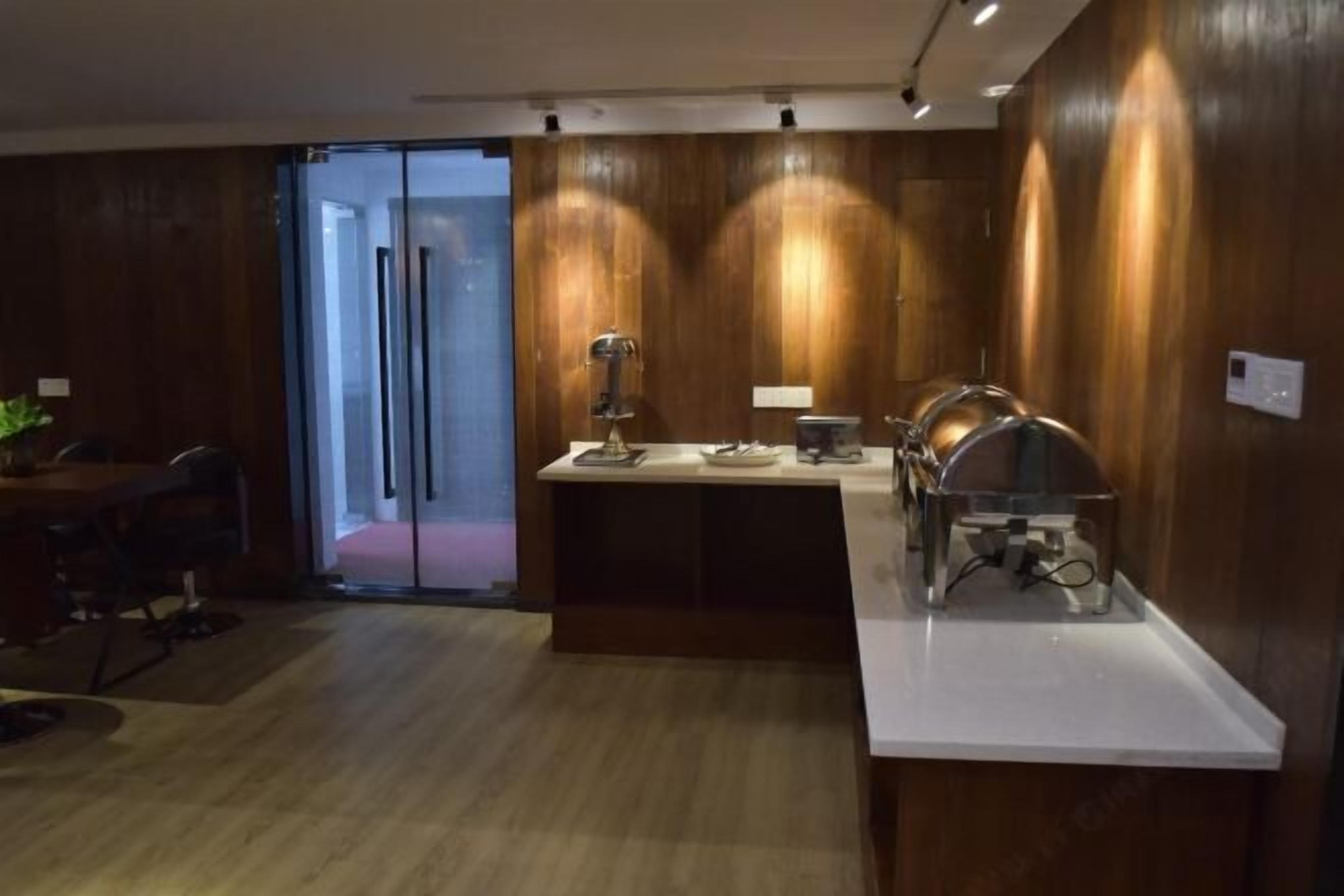 A modern kitchen with wooden paneling, a central island with a sink, and a built-in oven.