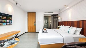 A modern hotel room with a large bed, a wooden bench, a wall-mounted TV, and a wooden door. - Jingkaisi Hotel (Taojialing Subway Station Renxinhui Branch) (Wuhan)