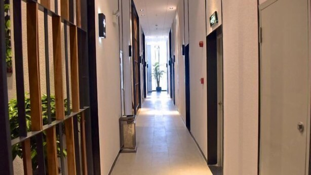 A hotel corridor with a long, narrow layout, featuring doors on both sides and a central walkway. - Jingkaisi Hotel (Taojialing Subway Station Renxinhui Branch) (Wuhan)