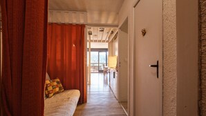 Un dormitorio con cama, cortinas y vista hacia un comedor.