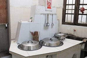 A kitchen with two stainless steel stoves, a window with bars, and a tiled backsplash. - Jixi Shangshufu Inn (Jixi)