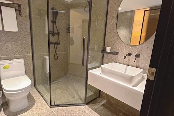 A bathroom with a glass-enclosed shower, a white sink, and a toilet. - Bozun Hotel Chongqing University City (Chongqing)