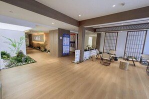 A hotel lobby with a wooden floor, reception desk, seating area, and a view of the outside. - Bozun Hotel Chongqing University City (Chongqing)