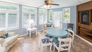 A dining area with a round table and chairs, a ceiling fan, and large windows. - Three Mermaids- New Listing Walk 2 Beach, Pool, Waterfront (Virginia Beach)