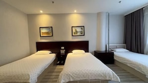 A hotel room with two single beds, a large window with curtains, and a nightstand with a lamp. - Xinranlin Hostel (Urumqi)