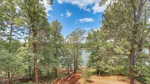 A wooden deck leading to a lake surrounded by tall trees. - Peaceful Greers Ferry Cabin w/ Deck & Lake View! (Greers Ferry)